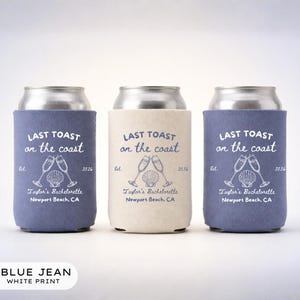 Op de afbeelding: Drie drankkoelers, twee in spijkerblauw en één in crème, met witte opdruk Last Toast on the coast, Est. 2026, Taylor's Bachelorette, Newport Beach, CA, en een afbeelding van twee champagneglazen en een schelp.