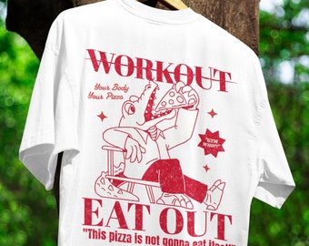 May include: White t-shirt with a red graphic of a cartoon alligator eating a pizza. The text "WORKOUT" is above the alligator and the text "EAT OUT" is below the alligator. The text "Your Body Your Pizza" is above the alligator and the text "This pizza is not gonna eat itself" is below the alligator.