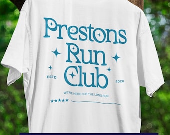 May include: White t-shirt with the text "Prestons Run Club" in teal. The design includes stars and the words "ESTD 2026" and "WE'RE HERE FOR THE LONG RUN". The bottom of the shirt reads "PERSONALIZE IT!"