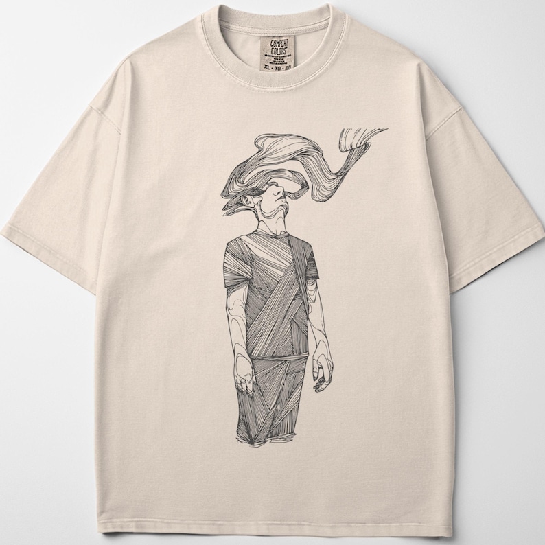 Comfort Colors® ivory unisex T-shirt shown flat on a light background; centered black line-art figure by Prakash printed on the front of a heavyweight cotton tee.