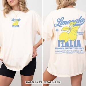 Comfort Colors® ivory t-shirt with large retro lemon back print and chest logo. Inspired by Sorrento, Italy. Model is 5’8”, wearing XL for an oversized look. Ideal summer travel and aesthetic outfit.