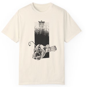 product view of comfort colors 1717, color ivory 
Hand-drawn anglerfish tee featuring a deep ocean scene with a boat and fisherman on the surface. Perfect for nature lovers, fans of retro 90s and 2000s style, and grunge fashion enthusiasts.