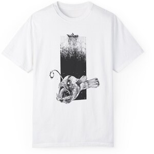 product view of comfort colors 1717, white. 
Hand-drawn anglerfish tee featuring a deep ocean scene with a boat and fisherman on the surface. Perfect for nature lovers, fans of retro 90s and 2000s style, and grunge fashion enthusiasts.