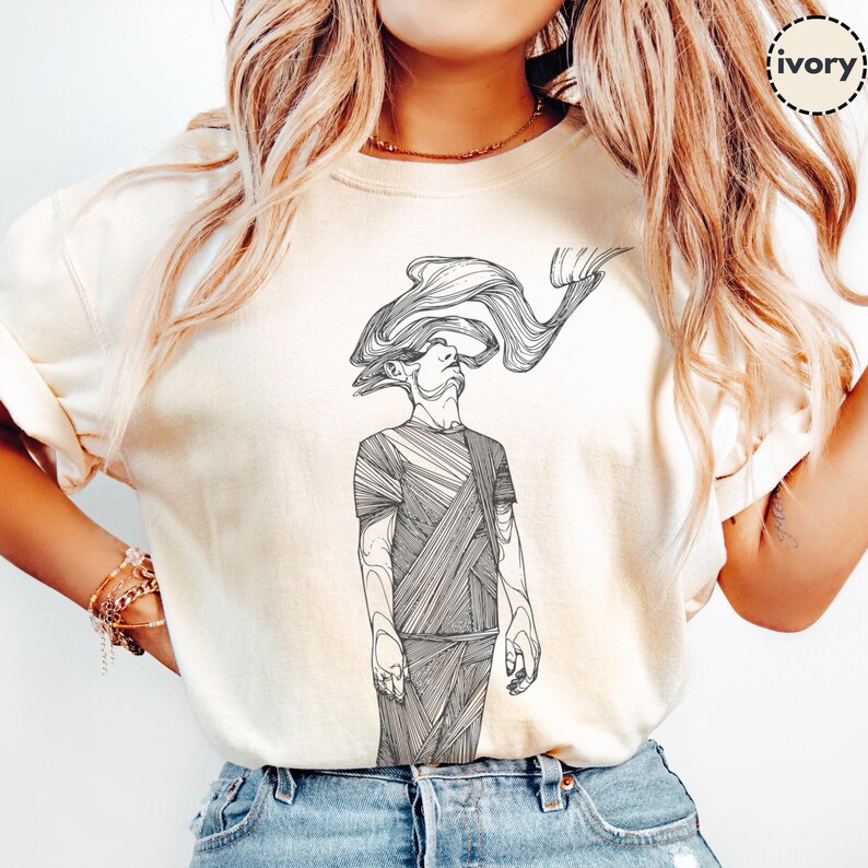 Comfort Colors® ivory unisex T-shirt featuring Prakash’s hand-drawn line-art figure; close-up on model with rolled sleeves to highlight the black front print and soft cotton texture.