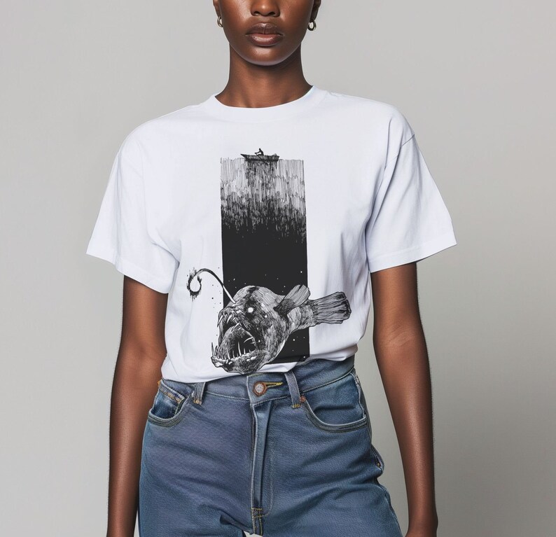 model wearing a white comfort colors 1717 tshirt with a Hand-drawn anglerfish tee featuring a deep ocean scene with a boat and fisherman on the surface. Perfect for nature lovers, fans of retro 90s and 2000s style, and grunge fashion enthusiasts.