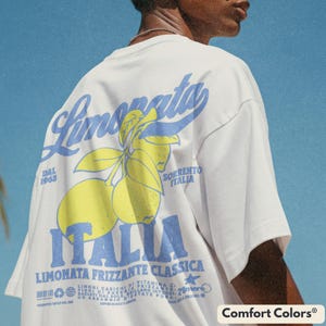 Back view of a unisex Comfort Colors® t-shirt in ivory with a large retro blue and yellow lemon graphic. Features bold “Limonata Italia” back print, inspired by vintage Italian soda labels. Summer streetwear, oversized fit.