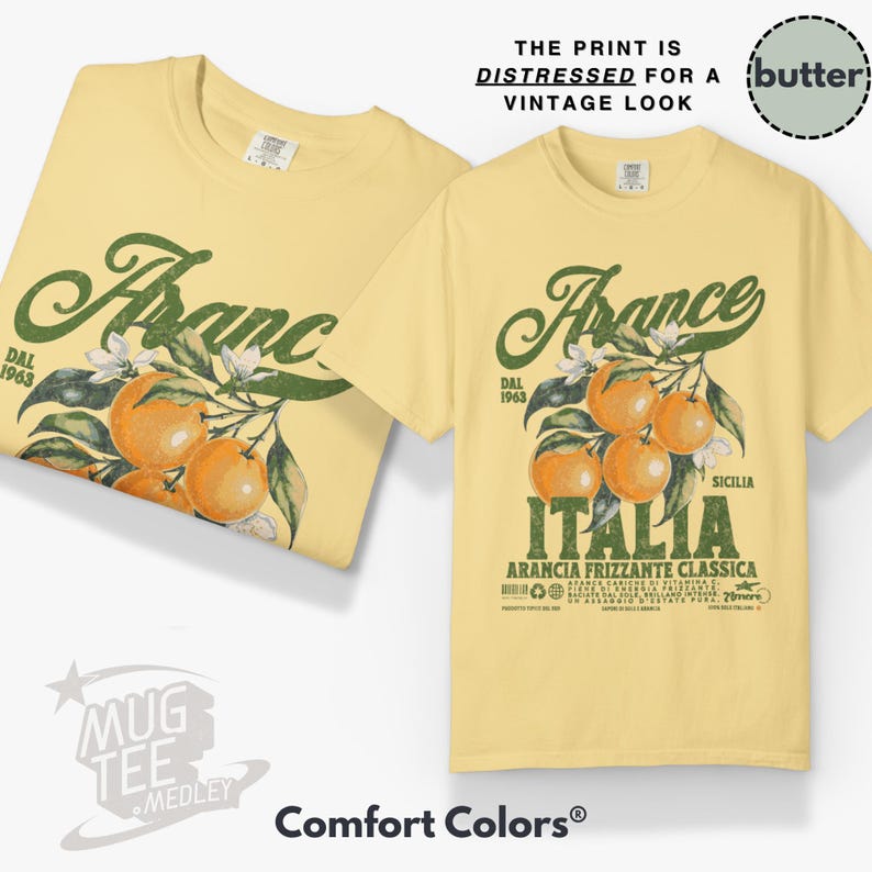 May include: Two light yellow t-shirts with a vintage-style graphic. The design features the word "France" in green script, oranges, and the word "Italia". The text "The print is distressed for a vintage look" is also visible.