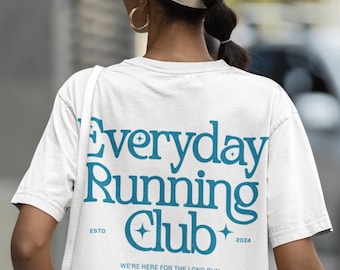 May include: White t-shirt with the text "Everyday Running Club" in teal. The shirt also features the text "ESTD 2024" and the phrase "WE'RE HERE FOR THE LONG RUN". The shirt has a crew neck and short sleeves.