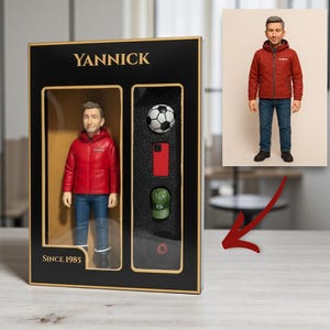 May include: A boxed figurine of a person wearing a red jacket and blue jeans. The box includes a soccer ball, a red phone, a green cap, and a red circle. The box is black with the name "YANNICK" and the text "SINCE 1985".
