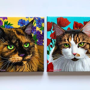 May include: Two square canvas paintings of cats. One features a brown and black cat with green eyes, surrounded by flowers on a yellow background. The other shows a white and brown cat with green eyes, with red poppies on a blue background.