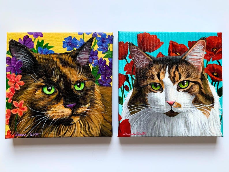 May include: Two square canvas paintings of cats. One features a brown and black cat with green eyes, surrounded by flowers on a yellow background. The other shows a white and brown cat with green eyes, with red poppies on a blue background.