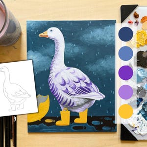 May include: An acrylic painting of a white goose with purple accents and yellow rain boots standing in the rain. The artwork is on a small canvas, with a color palette and a sketch of the goose nearby. A lit candle and art supplies are also visible.