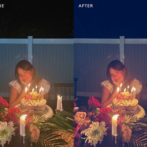 May include: A person sits at a table with a lit birthday cake with candles. The cake is decorated with flowers and is on a white plate. The table is decorated with flowers and greenery. The person is smiling and looking at the camera.