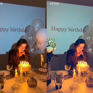 May include: A woman in a black shirt blows out candles on a birthday cake with the words "Happy birthday" written on a screen behind her.