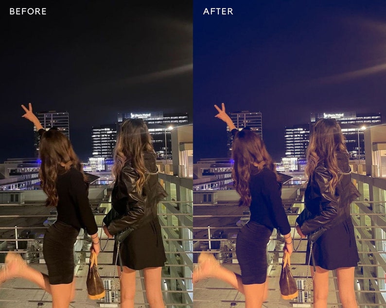 May include: Two people pose for a photo in front of a city skyline at night. They are both wearing black outfits and have their arms raised in the air. The city lights are visible in the background.