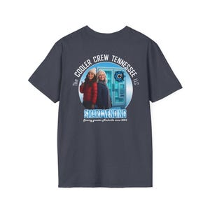 Peut inclure: T-shirt bleu marine avec un motif circulaire. Le motif comprend le texte "The Cooler Crew Tennessee LLC" et "Smart Vending". L'image montre deux femmes et un distributeur automatique. Le texte "Serving greater Nashville since 2025" est également présent.