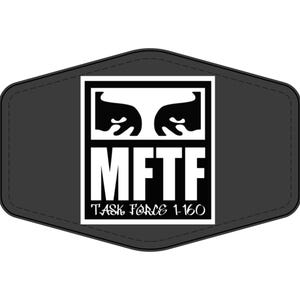 May include: A dark gray, hexagonal-shaped patch featuring a central white square graphic. The graphic displays two stylized black eyes above the bold white text MFTF and the smaller white text TASK FORCE 1-160, all enclosed within a black border.
