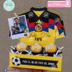 Puede incluir: Una caja de regalo amarilla con un balón de fútbol y el texto "PARA EL MEJOR PAPÁ DEL MUNDO." La caja contiene tres bombones dorados. Una foto de un padre y su hijo está sujeta a una camiseta de fútbol amarilla.