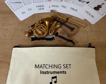May include: A set of toy musical instruments in a beige canvas bag with the words "Matching Set Instruments" and a musical note printed on it. The instruments include a trumpet, a french horn, a saxophone, a violin, a flute, a trombone, and a clarinet.