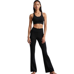 May include: A black athletic outfit consisting of a sports bra and flared yoga pants. The sports bra has a racerback design. The yoga pants are high-waisted and fitted through the hips, with a flared leg opening. The outfit is made of a stretchy, form-fitting material.