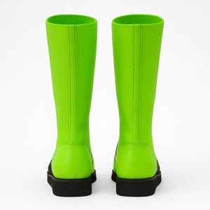 Professional product photo of neon green genuine leather wrestling boots with black flame design, black rubber sole, and lace-up closure. Displayed in bright, even lighting on a minimalist studio background, emphasizing fine stitching, craftsmanship, and glossy leather texture. Perfect unisex fight gear for wrestlers, performers, and cosplayers seeking bold, eye-catching ring footwear with durability and comfort.