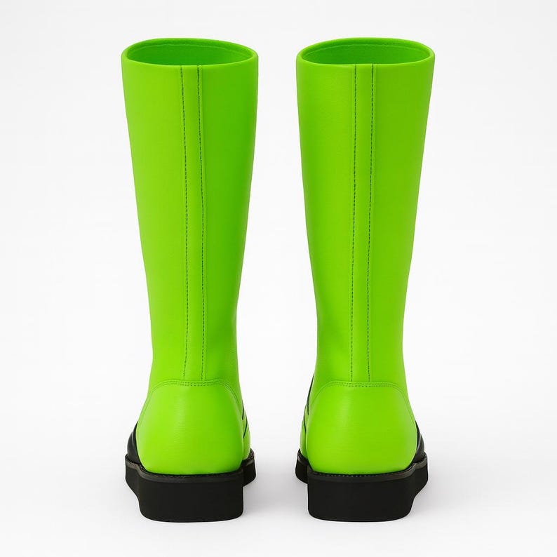 Professional product photo of neon green genuine leather wrestling boots with black flame design, black rubber sole, and lace-up closure. Displayed in bright, even lighting on a minimalist studio background, emphasizing fine stitching, craftsmanship, and glossy leather texture. Perfect unisex fight gear for wrestlers, performers, and cosplayers seeking bold, eye-catching ring footwear with durability and comfort.