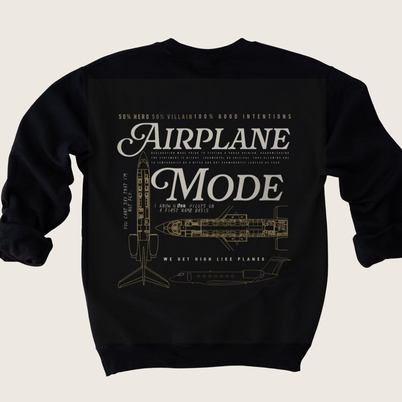 Op de afbeelding: Zwart sweatshirt met een gouden grafisch ontwerp van een vliegtuig met de tekst "AIRPLANE MODE" en de zin "WE GET HIGH LIKE PLANES".