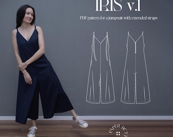 May include: A woman wearing a dark blue jumpsuit with extended straps, standing in front of a grey wall. The wall has a white outline of a jumpsuit with extended straps, and the text "IRIS v.1 PDF pattern for a jumpsuit with extended straps" above the outline. The text "PAPER BUTTON" is below the outline.