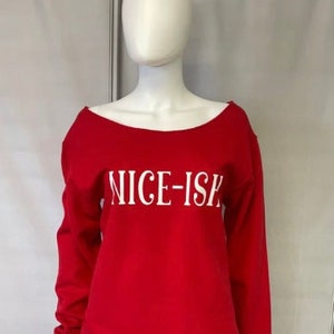 May include: Red long-sleeved sweatshirt with a white off-set neckline and the text "NICE-ISH" printed in white on the front.