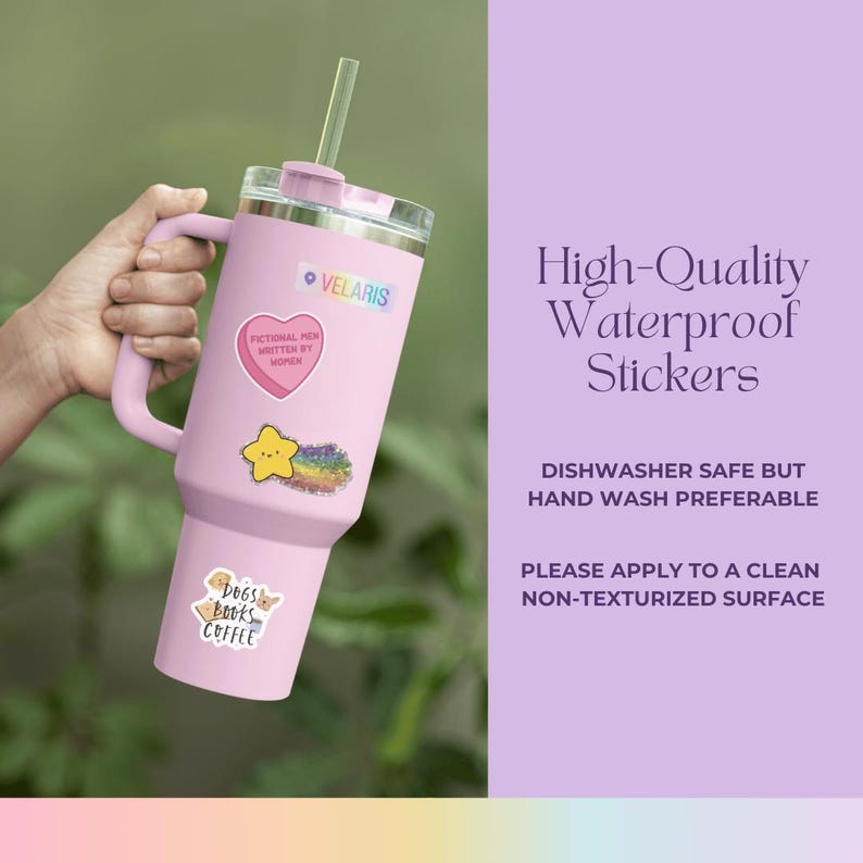 May include: A pink stainless steel tumbler with a handle and a straw. The tumbler has several stickers on it, including a heart with the text "Fictional Men Written By Women", a yellow star with a rainbow, and a sticker that says "Dogs Books Coffee". The text "High-Quality Waterproof Stickers" is written in white on a purple background. The text "Dishwasher Safe But Hand Wash Preferable" is written in black on a white background. The text "Please Apply To A Clean Non-Texturized Surface" is written in black on a white background.