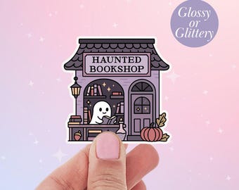 May include: A sticker featuring a whimsical illustration of a haunted bookshop. The shop has a purple facade with the words "HAUNTED BOOKSHOP" on a sign. A friendly ghost reads a book inside. A pumpkin and leaves are also featured.