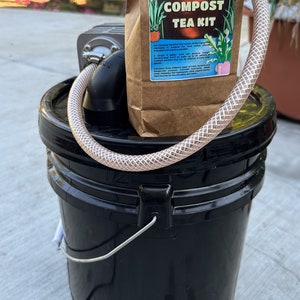 May include: A brown paper bag with the text "Act Brew Compost Tea Kit" and a black bucket with a hose and a pump. The bag is labeled "Bettergrow Hydro Microbial Inoculants".