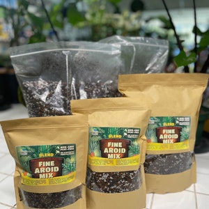 May include: Three brown paper bags filled with a dark brown soil mix. The bags are labeled "Fine Aroid Mix" and are non-GMO, peat-free, and have no synthetic fertilizers.