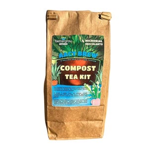 May include: A brown paper bag containing a BetterGrow Hydro AACT Brew Compost Tea Kit. The label features green plant illustrations, blue text reading AACT BREW, and yellow text reading COMPOST TEA KIT, with additional descriptive product text.