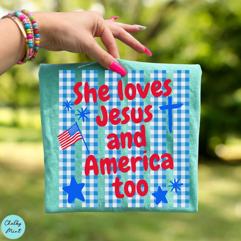 May include: A teal-colored square cloth with a blue and white checkered pattern. The text "She loves Jesus and America too" is written in red. An American flag, blue stars, and a blue cross are also featured.