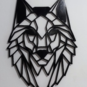 May include: Black geometric wolf head wall decor. The wolf is made of wood and has a black finish. The wolf's head is in a geometric style, with sharp angles and lines.