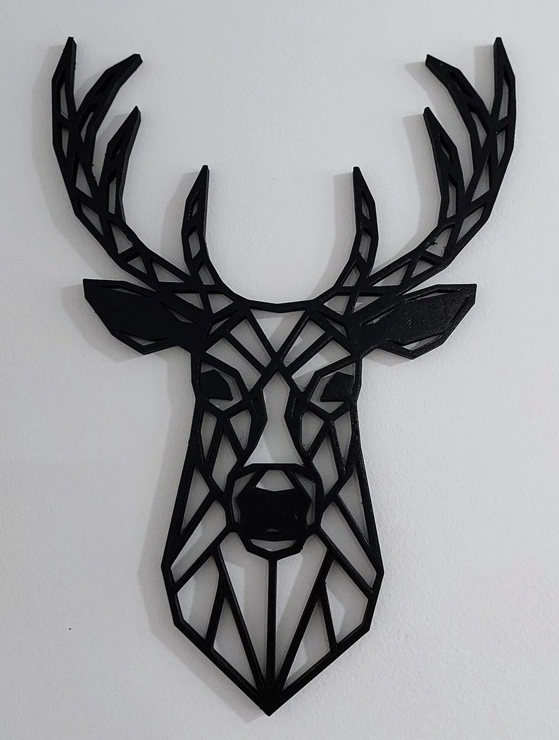 May include: Black geometric deer head wall decor. The deer head is made of wood and has a modern, minimalist design.