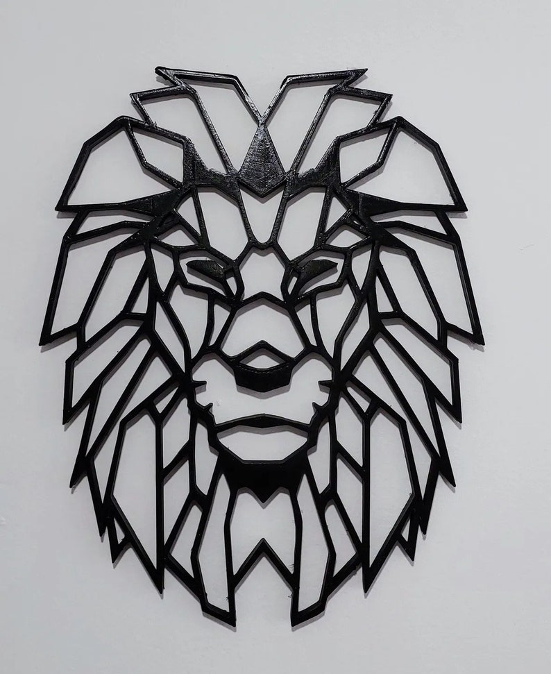 May include: Black geometric lion head wall decor. The lion's mane is made up of many triangles and lines.