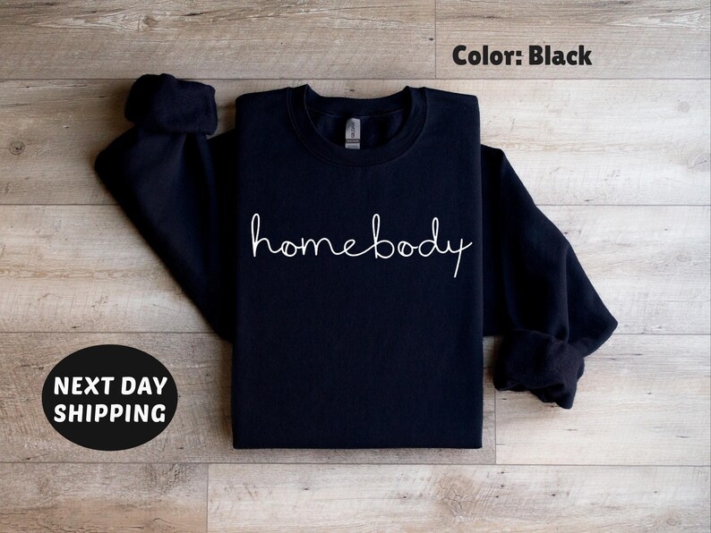 May include: Black sweatshirt with the text "homebody" written in white cursive.