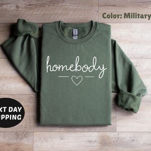 May include: A green sweatshirt with the text "homebody" in white lettering and a small heart symbol.