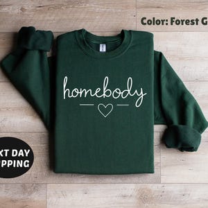 May include: Forest green sweatshirt with the text "homebody" in white lettering with a small heart in between the words.