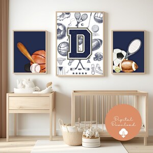 May include: Three framed prints with a sports theme. The central print features a navy blue letter "D" with sports equipment illustrations. The other two prints show a baseball bat, ball, and hockey puck, and a tennis racket, soccer ball, and football, all against a navy blue background.