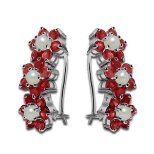 May include: A pair of silver earrings featuring a floral design. Each earring has three flower clusters with red gemstones and a central white pearl. The earrings have a hinged closure.