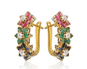 May include: Gold hoop earrings with a floral design featuring pink, green, blue, and white gemstones.