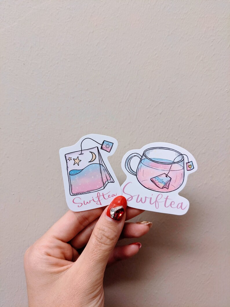 May include: Two stickers with a tea theme. One sticker shows a tea bag with a moon and stars, the other shows a teacup with a tea bag inside. Both stickers have the word "Swifttea" written on them.