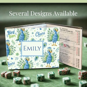 May include: A clear plastic Mahjong card sleeve featuring a repeating pattern of blue peacocks, green floral accents, and the text Bird Bam, Cheers, and Emily. The sleeve displays a printed Mahjong score card with columns for hands, dragons, and values.