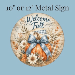 May include: A round metal sign available in 10-inch or 12-inch sizes featuring the text Welcome Fall. The design displays an orange pumpkin with a large blue bow, surrounded by white flowers, autumn leaves, and a plaid fabric pattern.