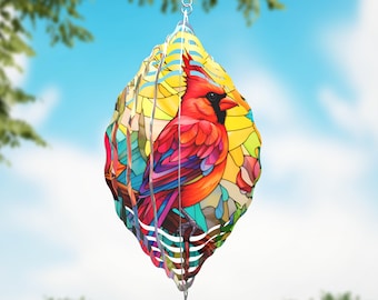 May include: A hanging metal wind spinner featuring a vibrant red cardinal bird perched on a branch. The design incorporates a colorful stained glass effect with yellow, blue, and green geometric patterns. It includes a silver swivel hook.