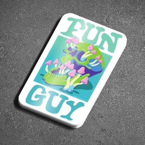 Könnte beinhalten: Ein weißer Aufkleber mit blauem und grünem Hintergrund. Der Aufkleber zeigt einen Schädel, aus dem rosa und weiße Pilze wachsen. Der Text "FUN GUY" ist in einer großen, bunten Schrift geschrieben.