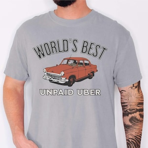May include: A grey t-shirt with the text "World's Best Unpaid Uber" and a vintage red car graphic.